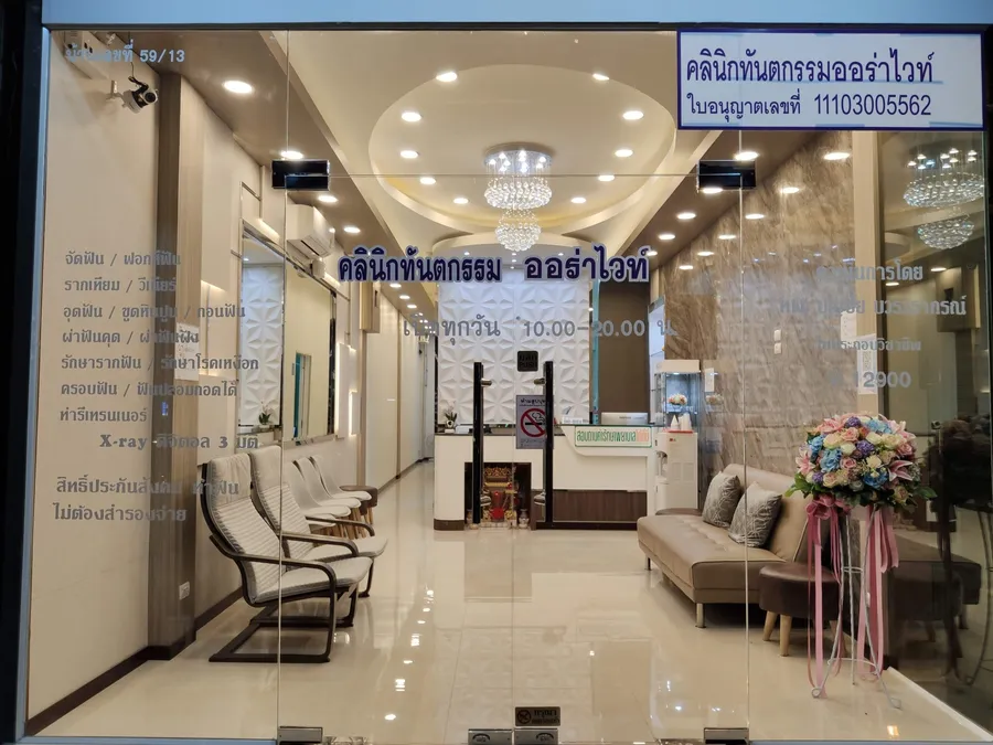 หน้าร้านและเคาน์เตอร์ต้อนรับของคลินิกทันตกรรมออร่าไวท์ มองจากทางเข้ากระจกด้านหน้า